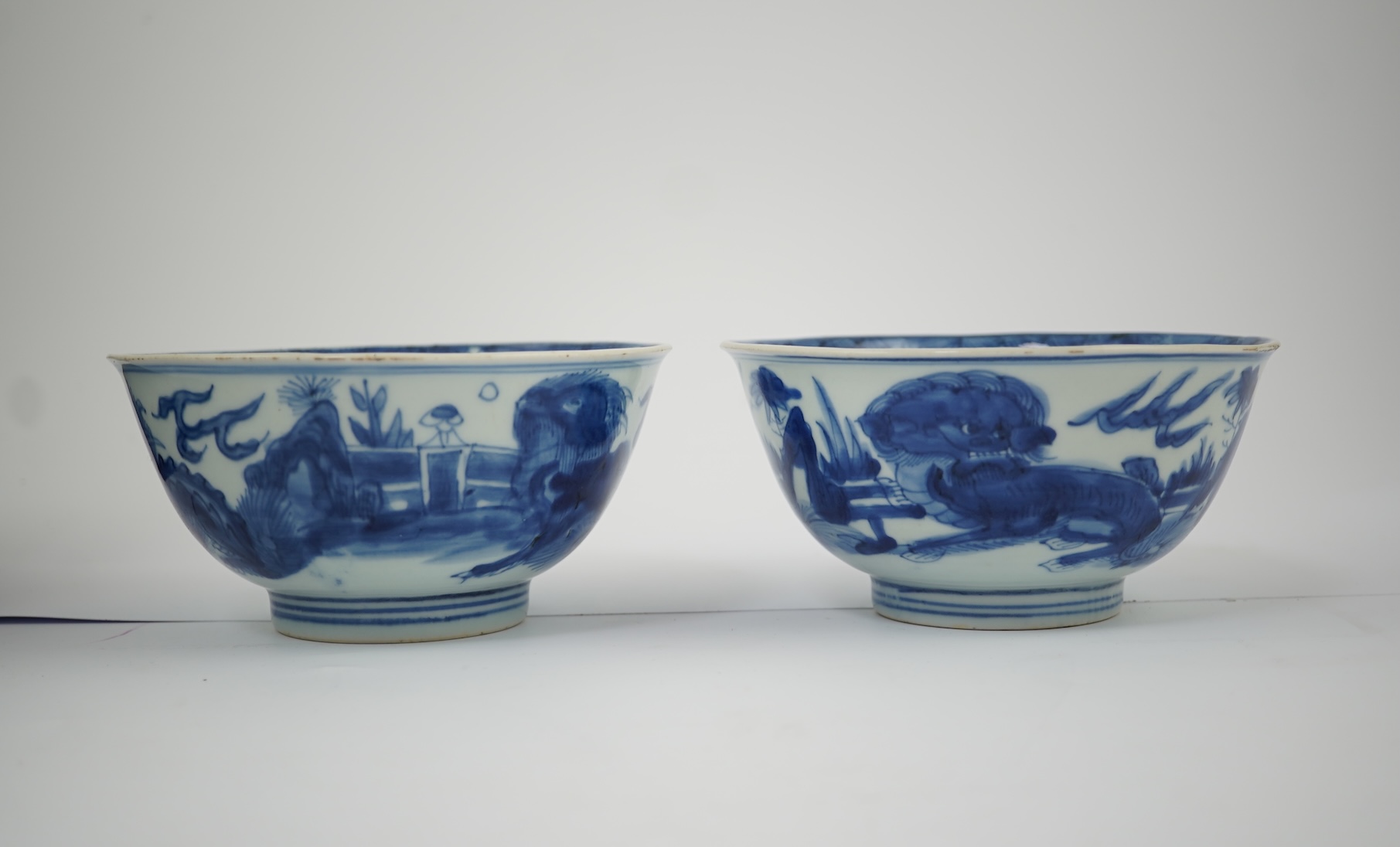 A pair of Chinese Transitional blue and white 'mythical beasts' bowls, early Kangxi period
